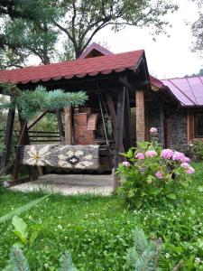 a gazebo with a bench in a yard at Casa Livada cu Meri in Vişeu de Jos