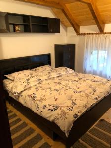 a bedroom with a bed with a floral bedspread at Casa Livada cu Meri in Vişeu de Jos