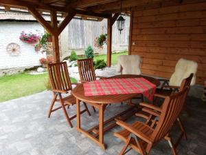 a wooden table and chairs on a patio at Mima Ubytovanie in Jamník