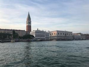 einen Blick auf die Stadt vom Wasser mit einem Uhrturm in der Unterkunft Arsenale Venice for Insider in Venedig