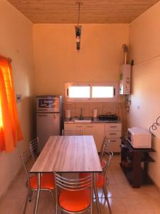une cuisine avec une table et des chaises. dans l'établissement Cabañas Buen Aike, à Malargüe