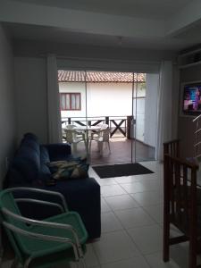 ein Wohnzimmer mit einem blauen Sofa und einem Tisch in der Unterkunft Casa de Veraneio in Governador Celso Ramos
