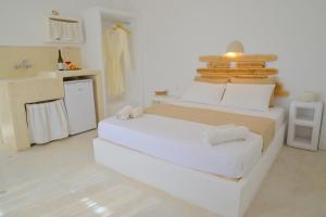 a white room with a bed and a kitchen at Fantasy Rooms in Adamantas