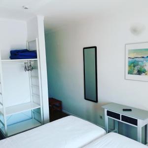 a bedroom with two beds and a mirror at Hotel Eira Da Pedra in Vila Nova de Milfontes