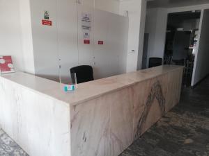 a reception counter in an office with chairs at Hotel Eira Da Pedra in Vila Nova de Milfontes