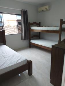 ein Zimmer mit zwei Etagenbetten und einem Fenster in der Unterkunft Casa de Veraneio in Governador Celso Ramos