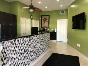 a kitchen with green walls and a black and white counter at Sun Coast Inn in Englewood