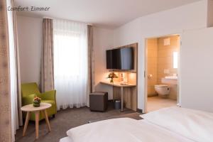 a hotel room with a bed and a tv at Brauerei-Gasthof Reichsadler in Mögglingen