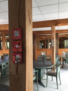 a table and chairs in a restaurant with tables and chairs at Hôtel De La Mare -restaurant pour les clients sur réservation in Avrigny