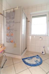 a bathroom with a shower and a rug on the floor at Nordseesonne Greetsiel in Krummhörn