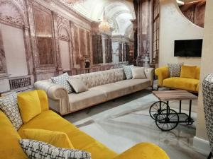 a living room with a large couch and yellow chairs at Allure Beach Resort Aparthotel in Primorsko