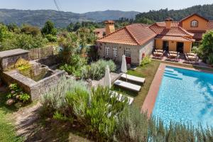 a villa with a swimming pool and a house at Casa do Eido - sustainable living & nature experiences in Valdosende