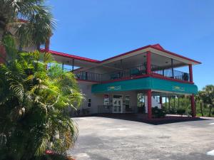 un edificio con un estacionamiento delante de él en Sun Coast Inn, en Englewood