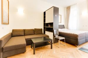 ein Wohnzimmer mit einem Sofa und einem Bett in der Unterkunft Hálkova Studio in Prag