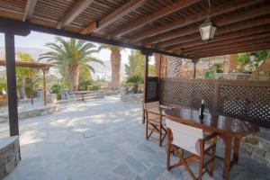 an outdoor patio with a wooden table and chairs at Paros Eden Park in Parikia