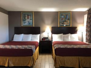 Postel nebo postele na pokoji v ubytování Sun Coast Inn