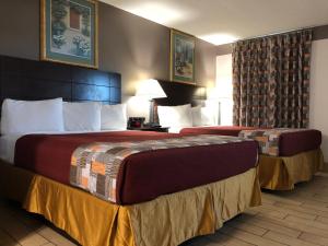 a hotel room with two beds in a room at Sun Coast Inn in Englewood