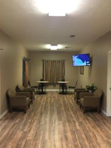 a waiting room with couches and a flat screen tv at Oak Tree Inn Eupora in Eupora