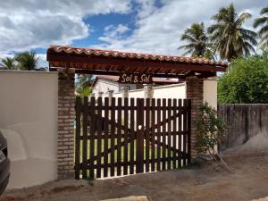a gate to a house with a sign on it at casa na praia de guajiru in Guajiru