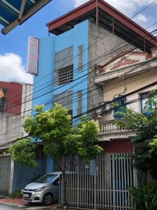 une voiture garée devant un bâtiment bleu dans l'établissement V A Motel, à Hai Phong
