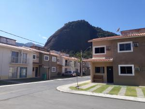 uma fila de casas com uma montanha ao fundo em Natureza e paz no Sahy em Mangaratiba