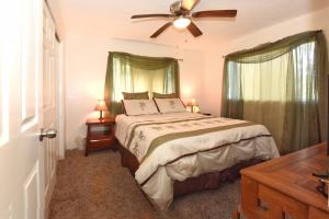a bedroom with a bed and a ceiling fan at Humble Home in Hawaii in Ainaloa