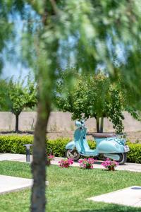 ein blauer Roller, der in einem Park mit Blumen parkt in der Unterkunft Ta Spitakia in Kos-Stadt
