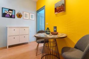 a yellow room with a table and two chairs at Matteotti 2 Apartment in Rovinj