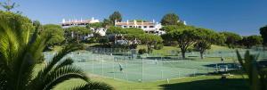 un grupo de personas jugando al tenis en una pista de tenis en Beach Villa Vale do Lobo, en Vale do Lobo
