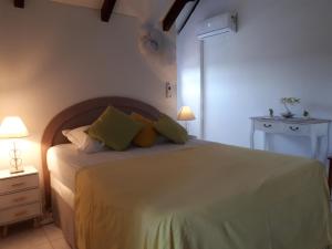 a bedroom with a large bed with green pillows at TI-WAIT in Sainte-Anne