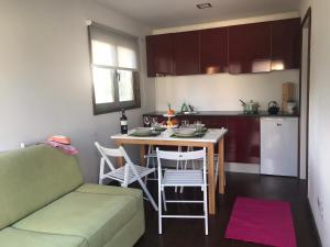 a kitchen with a couch and a table with chairs at Pousio- Rural Appartments in Vagos