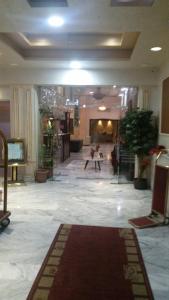 een lobby met een tapijt op de vloer van een gebouw bij Amman Ambiance Hotel  in Amman