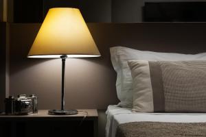 una lámpara sentada en una mesa junto a una cama en Apto 2Q com varanda no Ed Maximum Home, en Natal