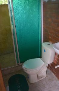 a bathroom with a toilet and a shower and a sink at Posada El Esfuerzo in Nuquí