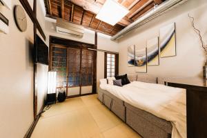 een slaapkamer met een groot bed in een kamer bij Prestige Suites Osaka Teradacho in Osaka