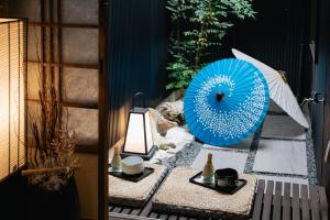 uma mesa com um guarda-chuva azul e um candeeiro em Prestige Suites Osaka Teradacho em Osaka