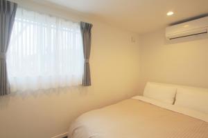 - une chambre avec un lit et une fenêtre dans l'établissement Villas Waraku, à Fujiyoshida