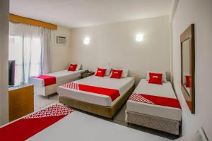 Habitación con 2 camas y almohadas rojas. en OYO Urupema Hotel, São Paulo, en São José dos Campos