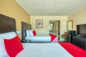 a hotel room with two beds and a flat screen tv at Hotel Belair Orlando Near Florida Mall in Orlando