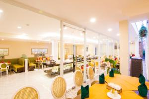 ein Wohnzimmer mit Tischen und Stühlen und ein Zimmer in der Unterkunft Phoenix Hotel Vung Tau in Vũng Tàu