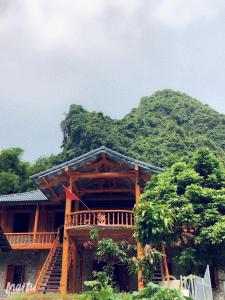 ein Holzhaus mit einem Berg im Hintergrund in der Unterkunft Khuổi Ky Eco Homestay in Cao Bằng