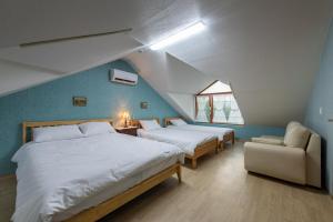 a attic bedroom with two beds and a couch at The Hyu Largo in Yongin