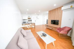 a living room with a couch and a table at แจสเปอร์โฮเทล Jasper Hotel in Ban Phai