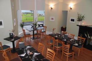 RaasayRaasay House Hotel的一间带桌椅和壁炉的用餐室