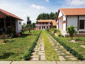 een tuin met een stenen pad voor een huis bij CocoPalm Villa near Beach - Palm Room in Ấp Mỹ An