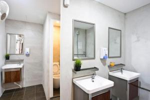 een witte badkamer met 2 wastafels en een toilet bij 7 Wonders Boutique Capsule in Singapore