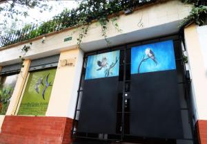 een gebouw met deuren met foto's van vogels erop bij Bird Garden Guest House in Quito