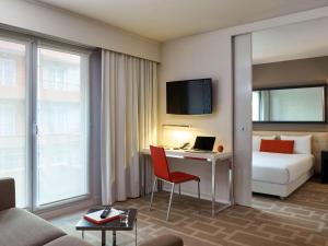 a hotel room with a bed and a desk with a laptop at Adagio Grenoble Centre in Grenoble