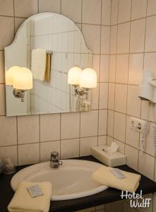 a bathroom with a sink and a mirror at Hotel Wulff in Warburg