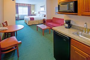 a hotel room with a kitchen and a bedroom at Holiday Inn Express Hotel and Suites Valparaiso by IHG in Valparaiso